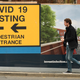 A pedestrian walks past a sign directing members of the public to a covid-19 testing center in Bolton, England, on May 28, 2021.